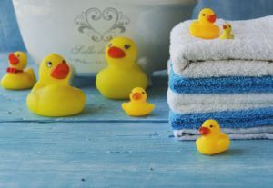 stack of colorful towels and bath duck on the table