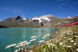 Rhaetian Railway/RhB - Bernina Express running beside Lake Bianco.